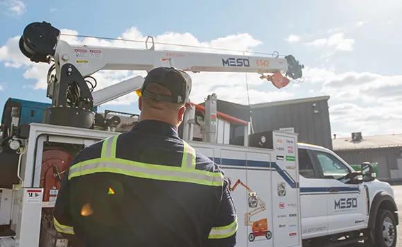 worker standing in front of a boom truck